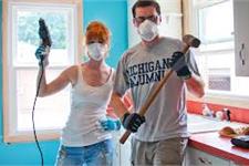 2 People Holding Hammers During Room Construction